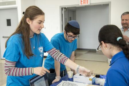 "START Science volunteers work with schoolchildren at one of the event's six science stations." "